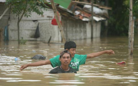 GN/Istimewa Dua warga tampak berjalan di tengah banjir yang mencapai setinggi dada orang dewasa