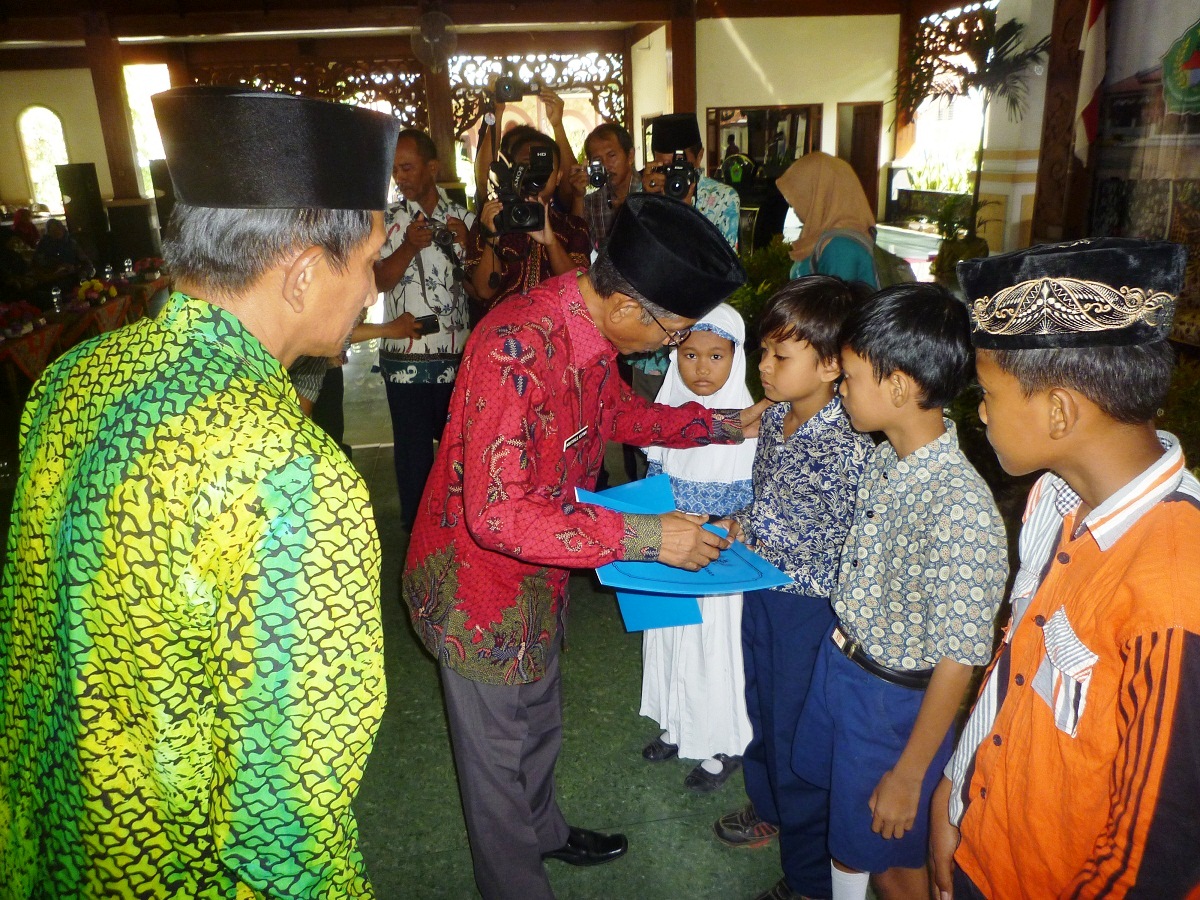 GN/Masdawi Dahlan Wakil Bupati Pamekasan Khalil Asyari memberikan santunan pada perwakilan anak yatim dalam peringatan Israk Mikraj, Kamis (26/5/2106).