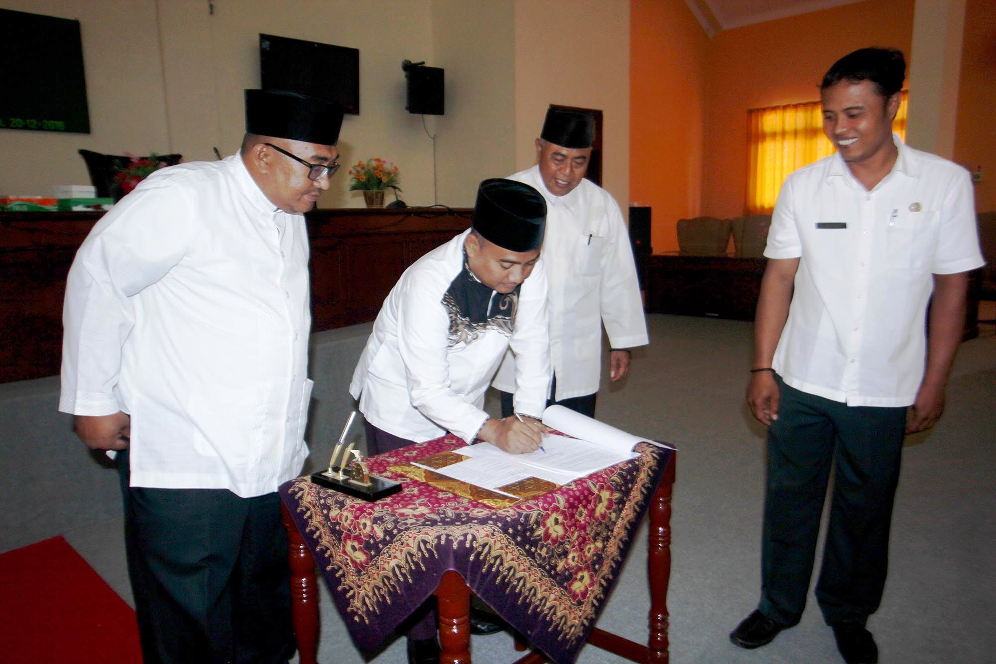 GN/MAHARDIKA SURYA ABRIANTO Ketua DPRD Kabupaten Sampang Imam Ubaidillah (tengah) meneken berita acara 4 raperda. 
