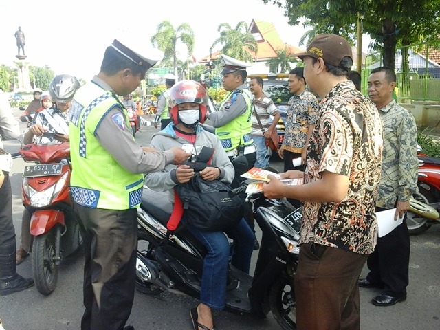 GN/Chusnul Huda Salah seorang pengendara memberikan surat-surat kelengkapan berkendara di jalan raya.