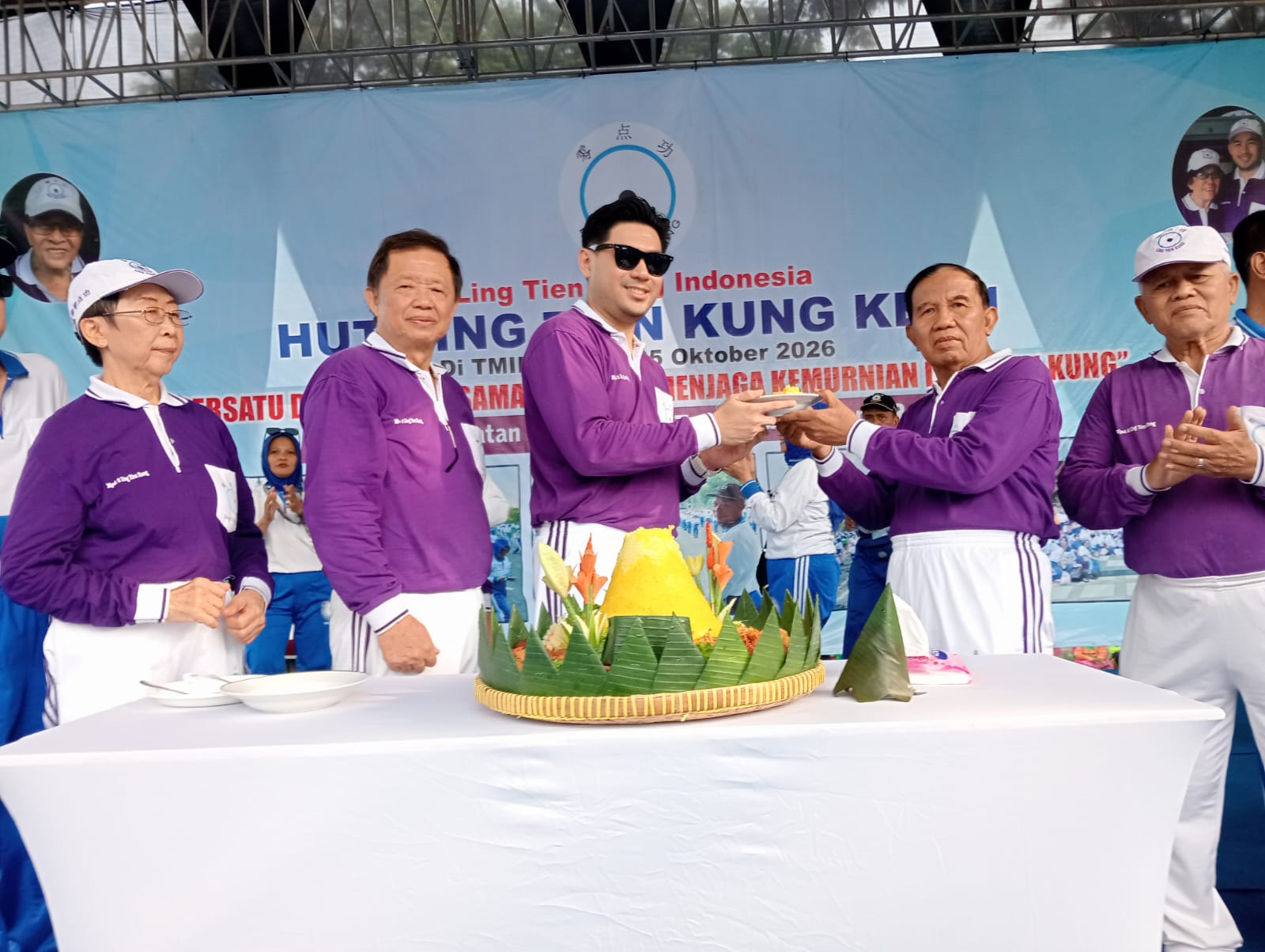 Penyerahan potongan tumpeng dari Shane (berkacamata) kepada Edy Prawoto.